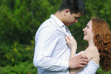 beautiful young couple in love on a green glade