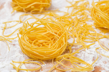 Italian egg pasta nests on a floured cutting board
