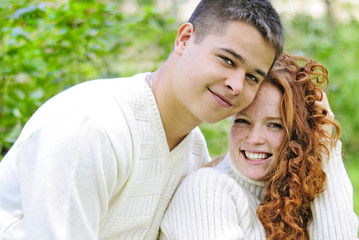 Obraz premium Young beautiful couple in the park in the white jerseys
