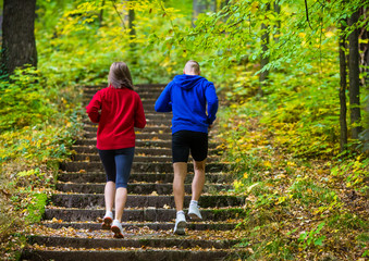 Healthy lifestyle - woman and man running in park