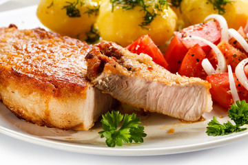 Grilled steaks, boiled potatoes and vegetable salad