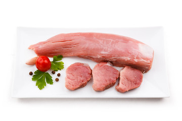 Raw pork loin and vegetables on white background