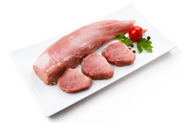 Raw pork loin and vegetables on white background