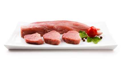 Raw pork loin and vegetables on white background