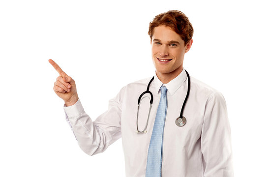Smiling young physician pointing away