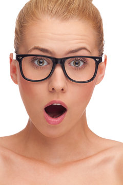 Close-up of a young woman in glasses looking surprised.