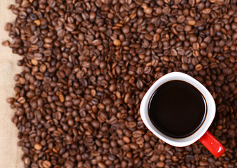 Cup of coffee on coffee beans background
