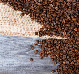Sack of coffee grains on wooden background