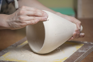 Girl make vase from clay