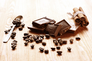 chocolate, cinamon and coffee beans on wooden table