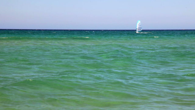 Windsurfer moving on turquoise water of sardinian sea