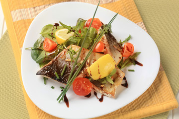 Fish fillet with salad greens and tomatoes