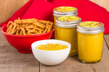 Jars of homemade mustard with pretzels