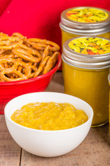 Jars of homemade mustard with pretzels