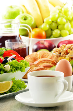Breakfast with coffee, juice, croissant, salad, musli and egg