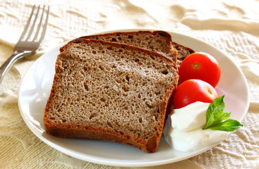 sliced bread  with spread cheese, decorated with a cherry tomato