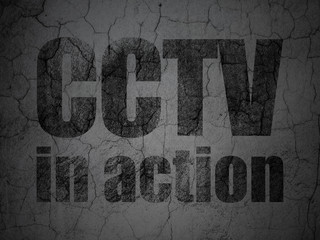 Safety concept: CCTV In action on grunge wall background