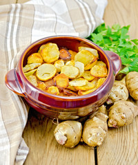 Jerusalem artichokes fried in a pan on the board