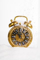 Antique gold clock in the snow. with copy space on a white backg