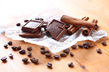 chocolate, cinamon and coffee beans on wooden table