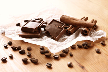 chocolate, cinamon and coffee beans on wooden table