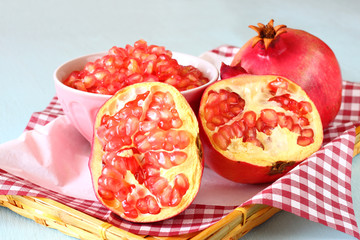 pomegranate on wooden table, and fresh pomegrante seed in bowl