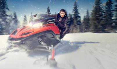 Fotobehang man on snowmobile © luckybusiness