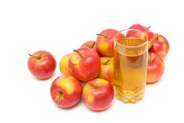 apple juice in glass and ripe apples on a white background.