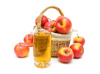 apple juice in a glass and a basket of apples on a white backgro