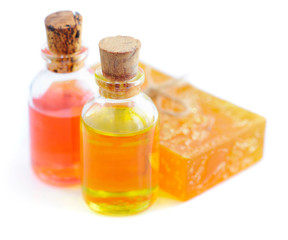 Essential oils are with floral soap on white background