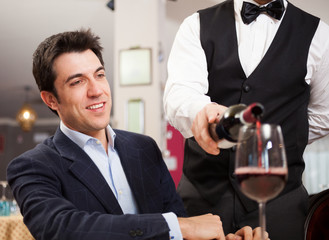 Waiter pouring wine