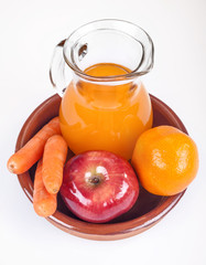 apple, orange and carrots with fresh juice in the background