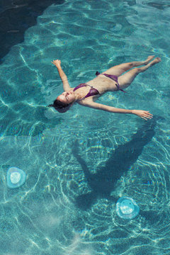 Girl floating in swimming pool