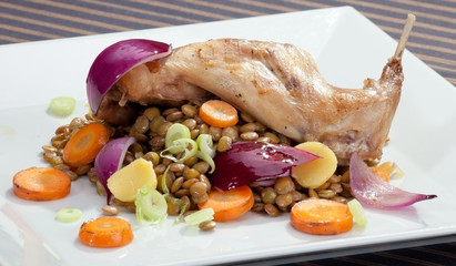 Baked rabbit leg with lentil and vegetable garnish