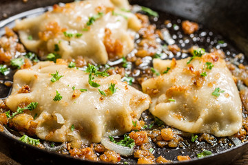 Closeup of .dumplings fried with onion and parsley