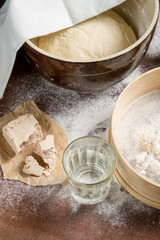Yeast dough let stand to rise on ld wooden table