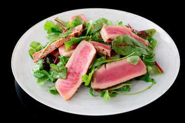 Appetizer with rare fried tuna isolated on black