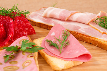 Sandwiches with salami, bacon and mortadella