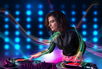 Young Dj girl mixing records with colorful lights