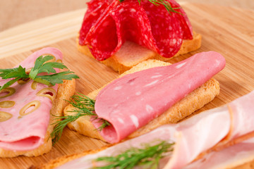 Sandwiches with salami, bacon and mortadella