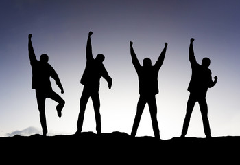 Silhouette of a team on the mountain top.