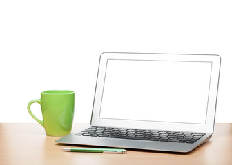 Laptop with blank screen and cup on table