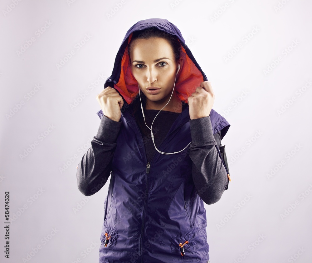 Wall mural Confident female athlete in hoodie