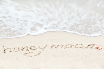 Honeymoon - written in sand on beach texture - soft wave of the 