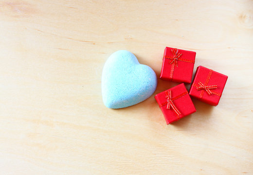 red gift box and heart shape on wooden background
