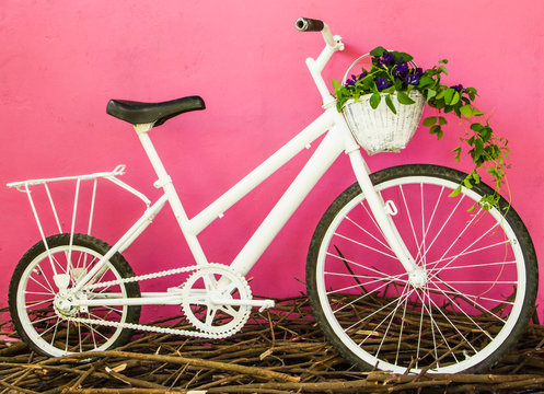 White bicycle on pink wall