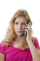 Fototapeta premium Girl is calling on mobile phone loking sad