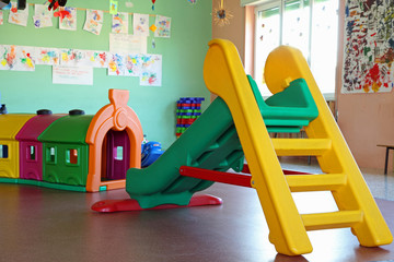 slide and plastic tunnel in the playroom of a preschool