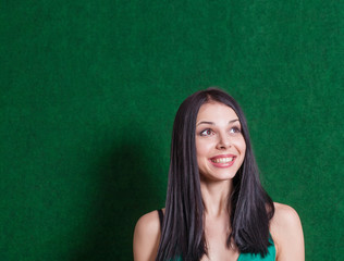 brunette in green dress against wall