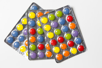 Farbige Tabletten auf weißem Hintergrund